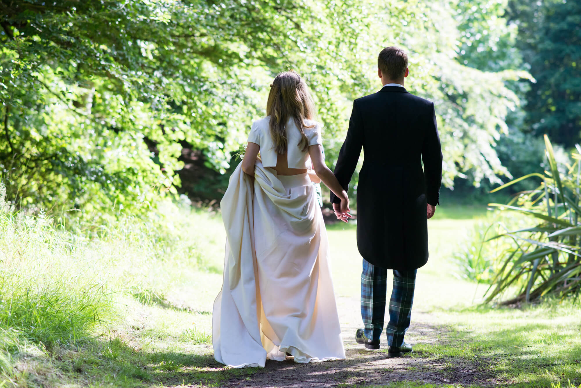 A couple in the grounds of Gosford House holding hands and having their wedding photography taken